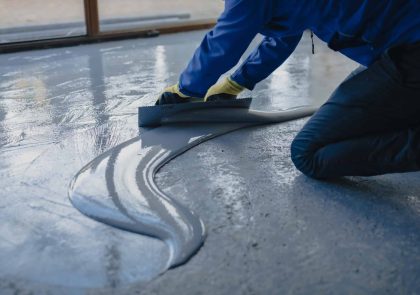 The worker applies gray polyurea to the new floor